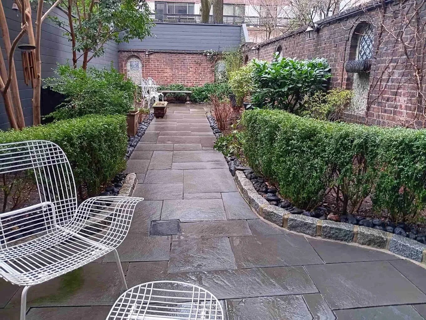 Bluestone garden path lined with boxwood hedges and granite curbing